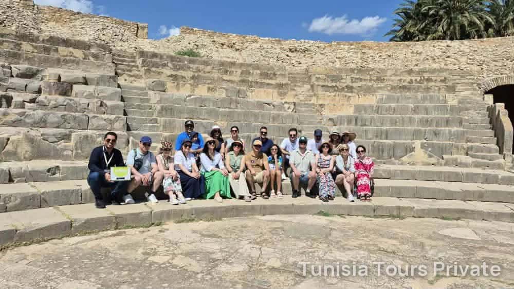 Группа сидит на каменных ступенях римского театра