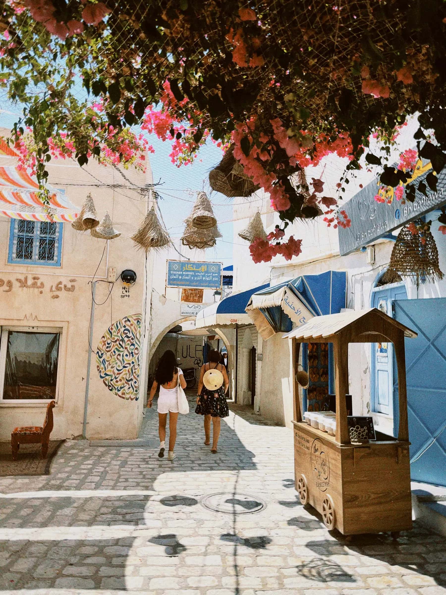 Una calle soleada de Djerba con casas encaladas y buganvillas en flor
