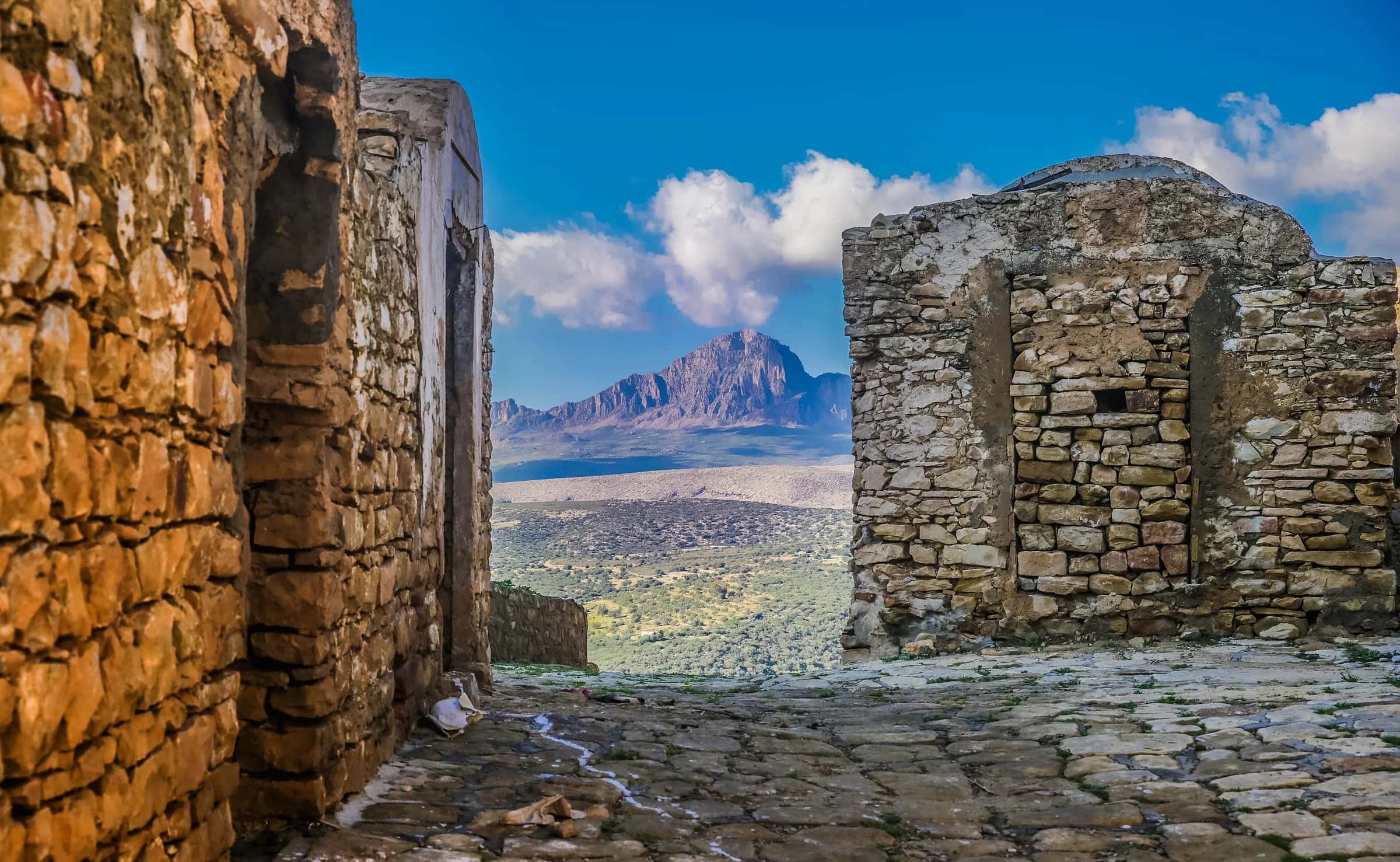 Uma ruela de pedra de Zriba Olia a enquadrar o cume do Djebel Zaghouan