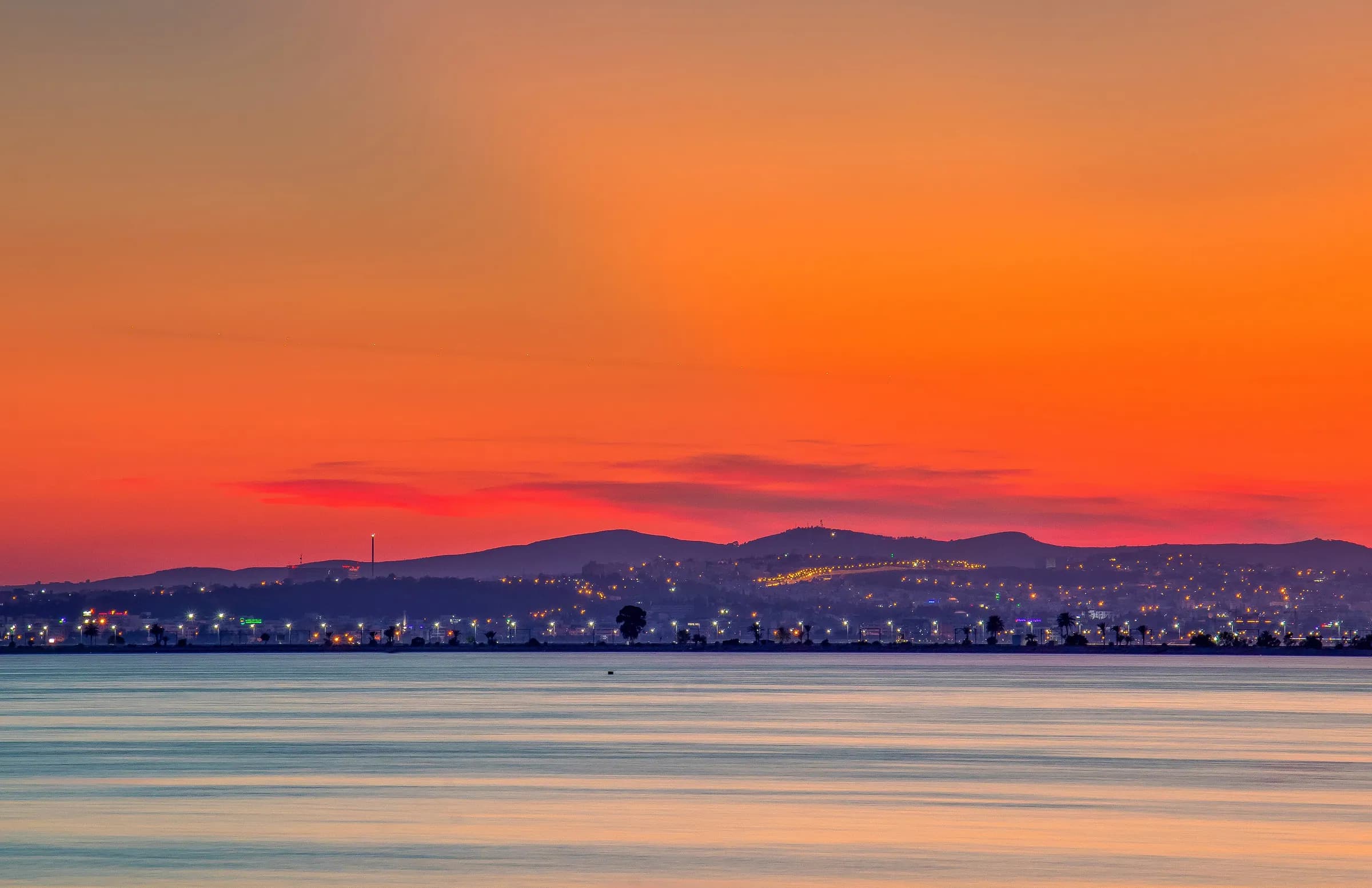 Un tramonto arancione sul lago di Tunisi, tra la città e La Goulette