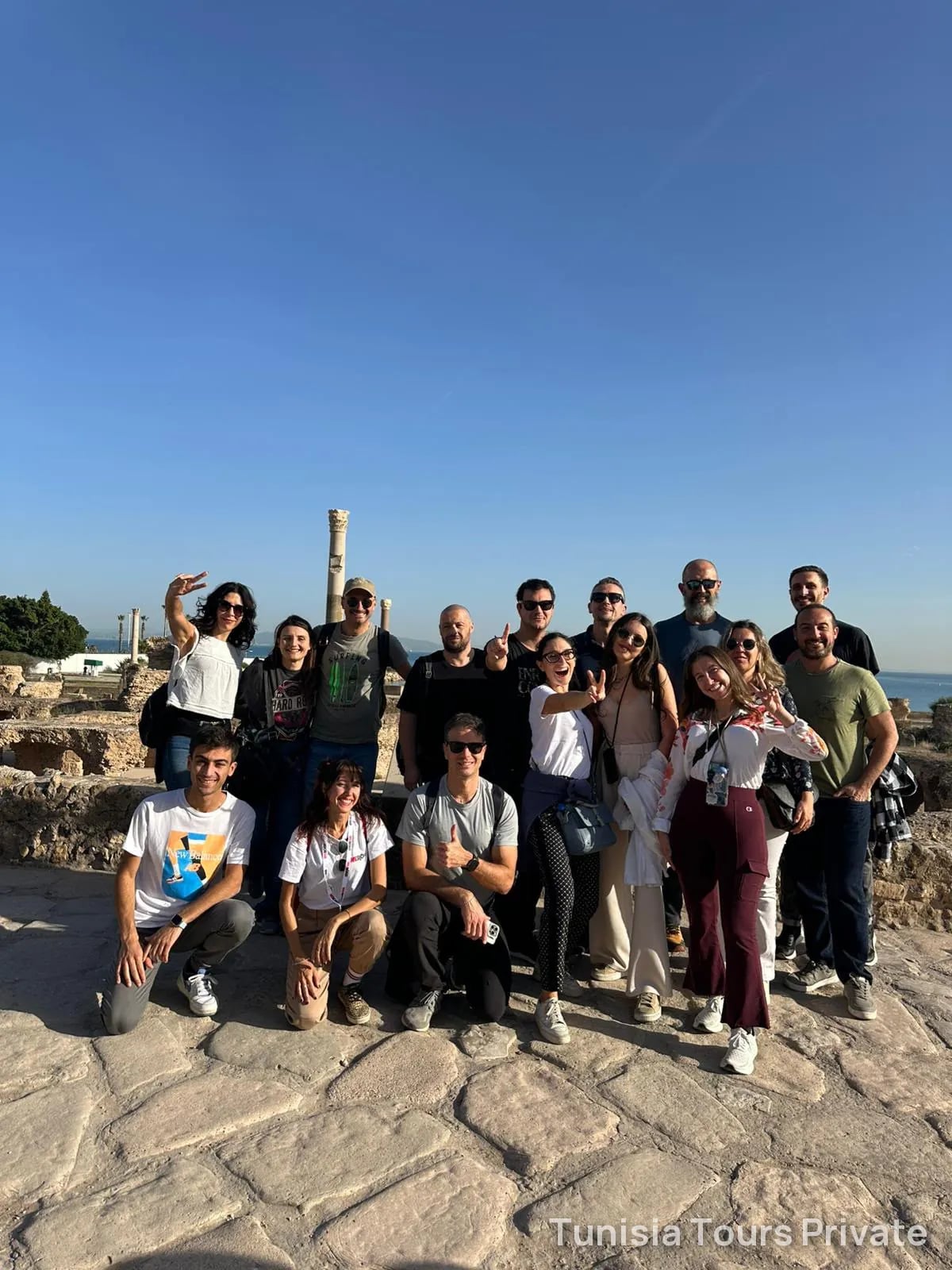 A group of guests among the ruins of Carthage on a sunny day